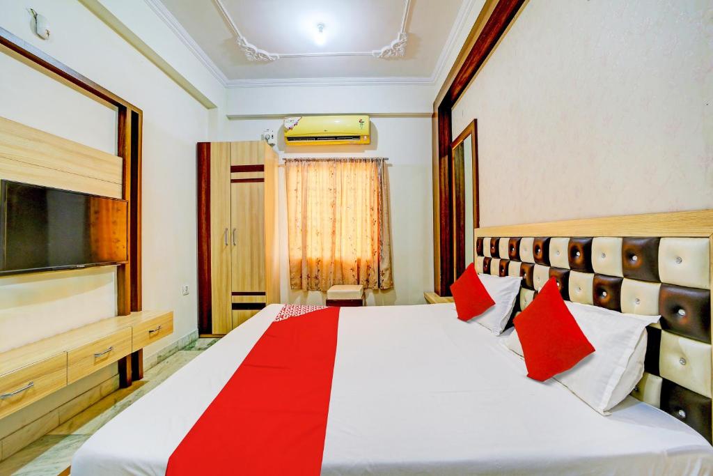 a bedroom with a large bed with red pillows at OYO Hotel My Lord in Bhopal