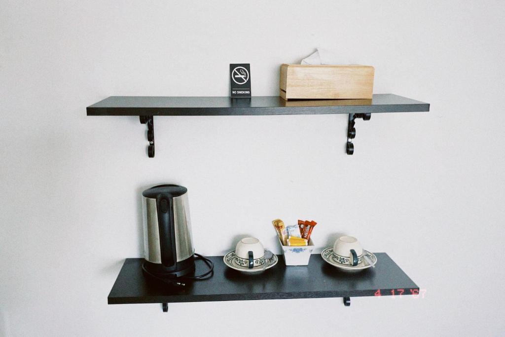 a black shelf with a coffee maker and cups on it at Sasimanta in Kamala Beach