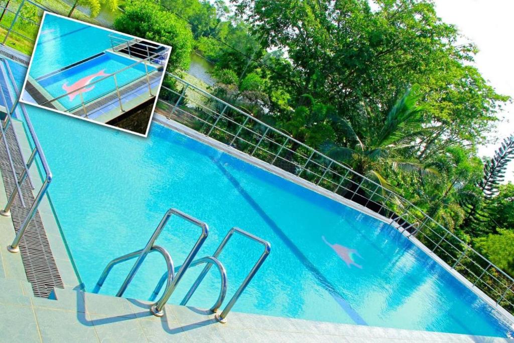 River Top Holiday Resort في Bandaragama: مسبح ازرق كبير بجانب سياج