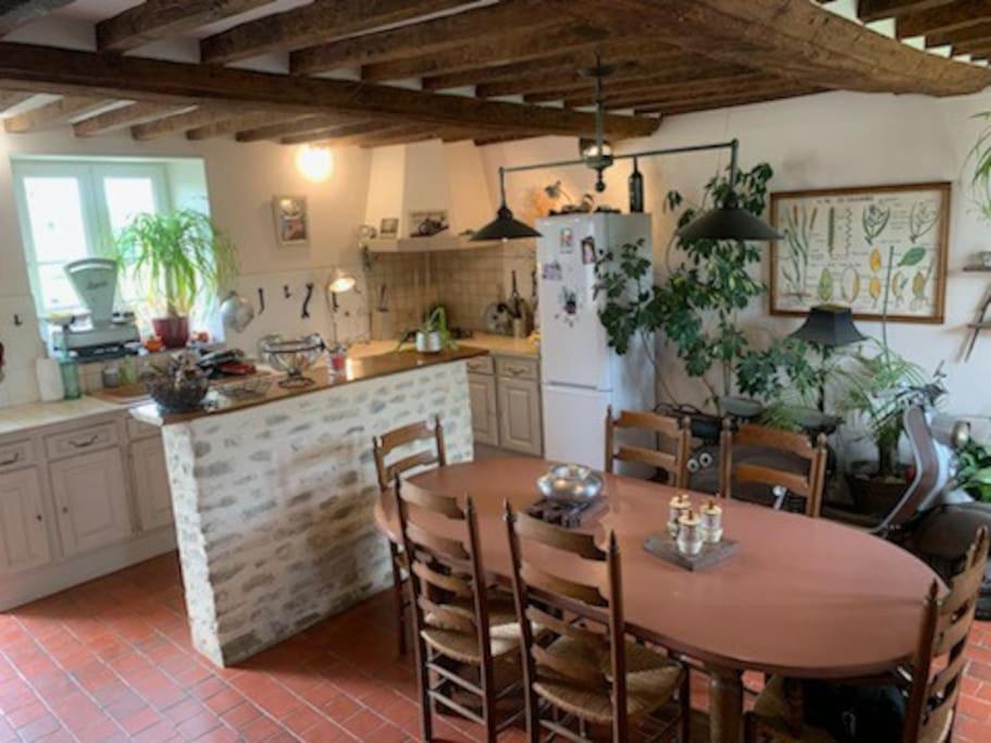 cocina con mesa de madera y cocina con nevera en Maison à louer, en Noron-la-Poterie