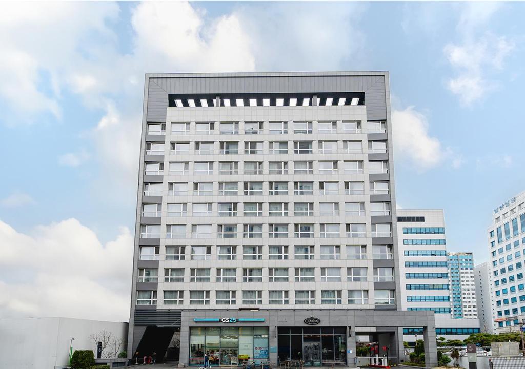 wysoki biały budynek z mnóstwem okien w obiekcie Grand City Hotel Changwon w mieście Changwon