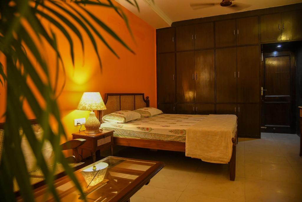 a bedroom with a bed and a table and a plant at Himtrek Stays Delhi in New Delhi
