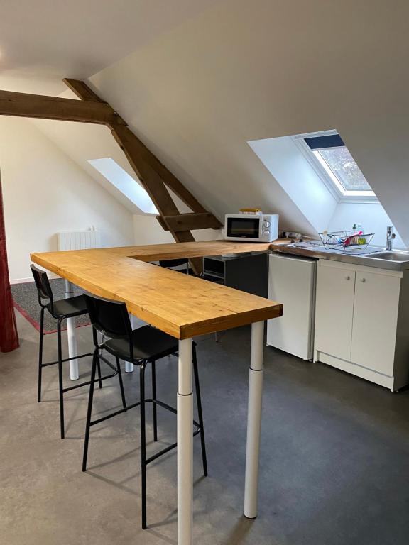 a kitchen with a wooden table and some chairs at La campagne près de la ville Nouveau propriétaire in Monnaie