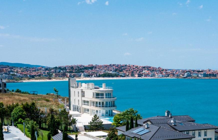 un grande edificio bianco accanto a un grande bacino d'acqua di The LODGE Summer Apartments Sozopol a Sozopol