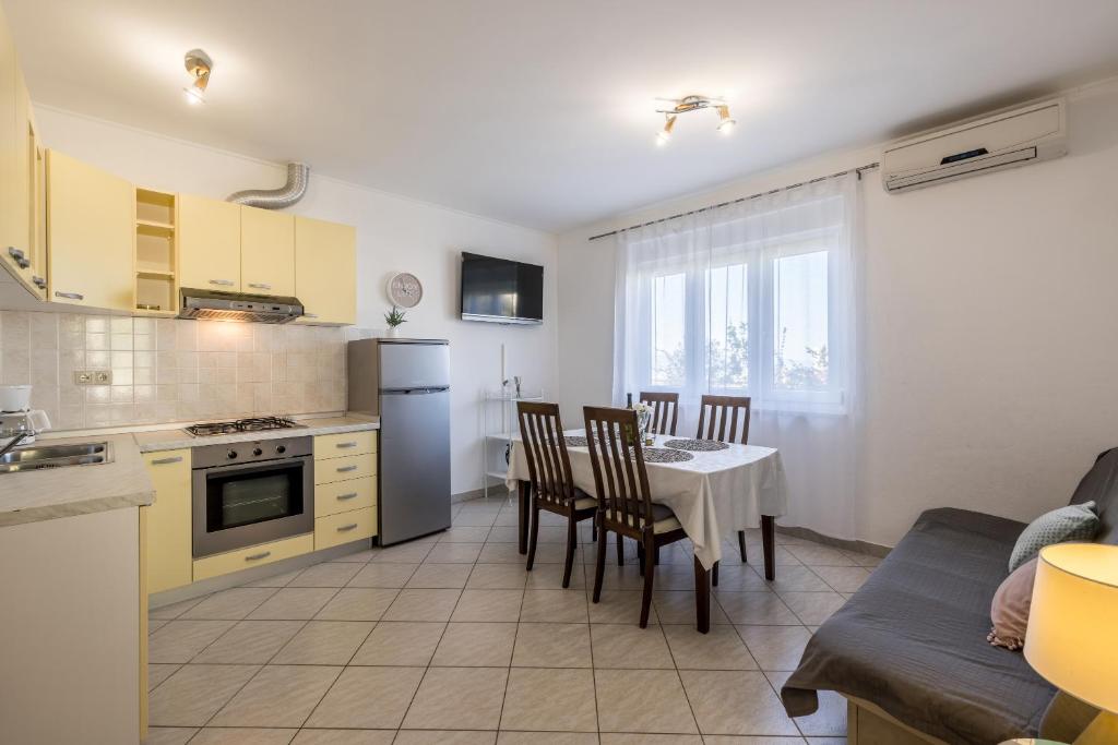 una cucina e una sala da pranzo con tavolo e sedie di Cozy Apartment Tony a Dugi Rat (Punta Lunga)
