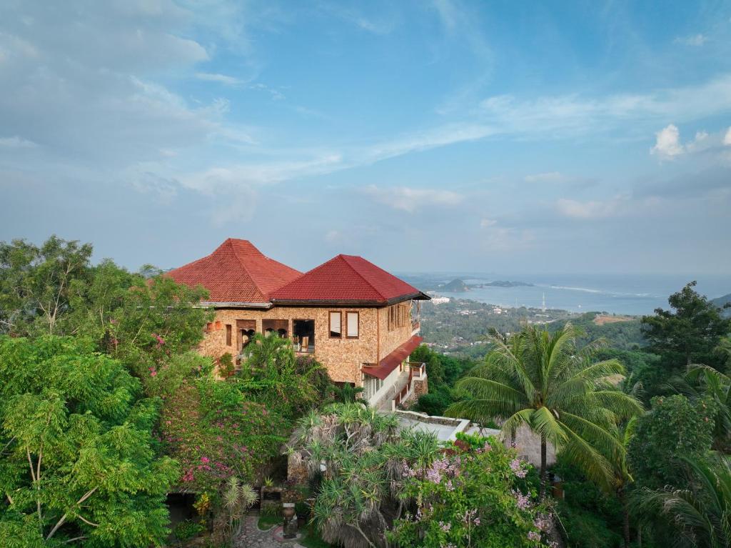 a house on top of a hill with trees at Ashtari - Sky, Sea & Nature in Kuta Lombok