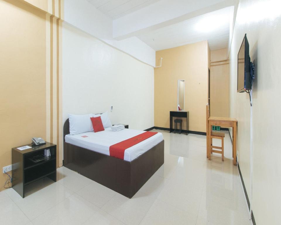 um quarto com uma cama e uma televisão em RedDoorz near SM City Muntinlupa em Manila