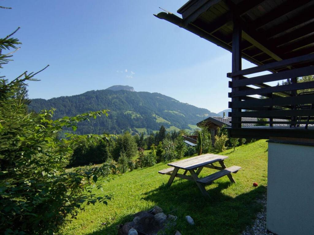 a picnic table in a field with a mountain in the background at Chalet Grand Wastl in Wörgl