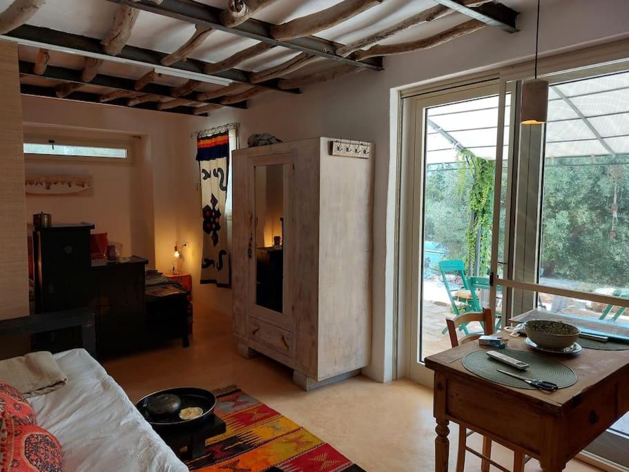 een woonkamer met een tafel en een groot raam bij Conibianchi in Ceglie Messapica