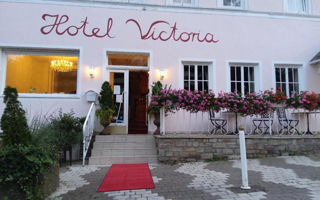 ein weißes Gebäude mit einem Schild, das die Hotel Victoria liest in der Unterkunft Hotel Victoria in Schlangenbad