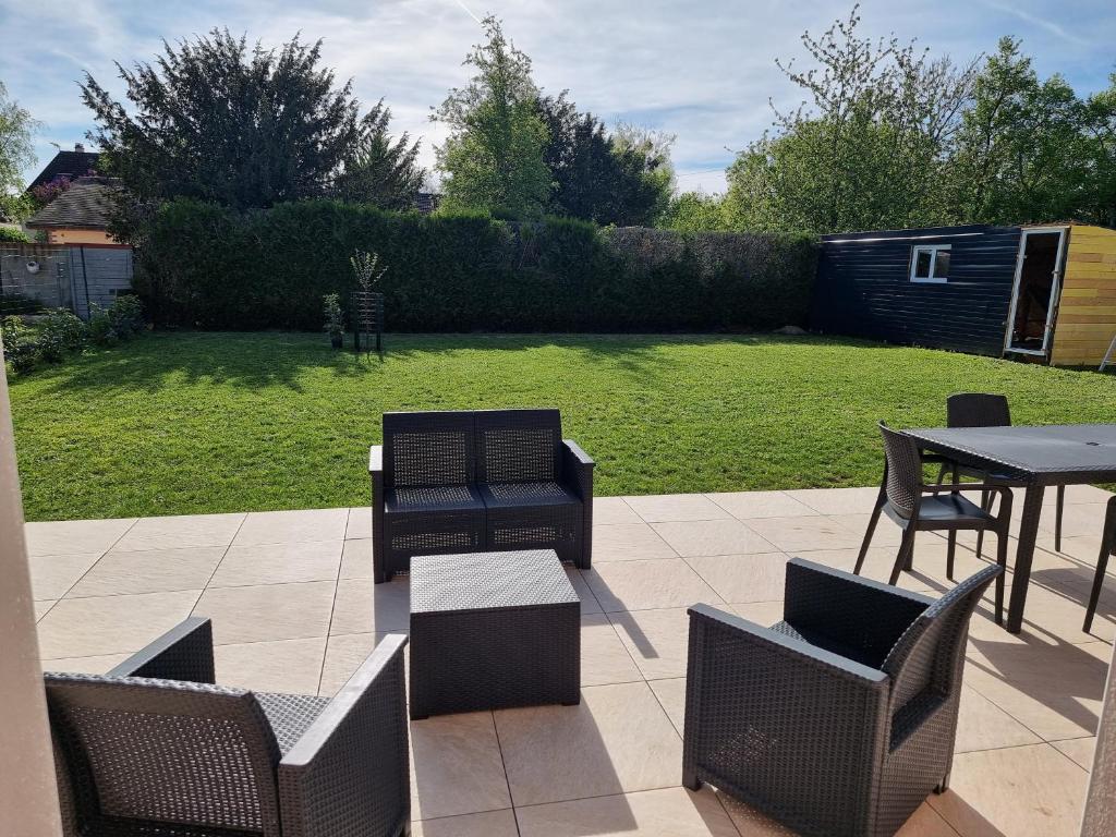 d'une terrasse avec des chaises, une table et une table. dans l'établissement Agréable Maison proche Lac du Der, à Valcourt