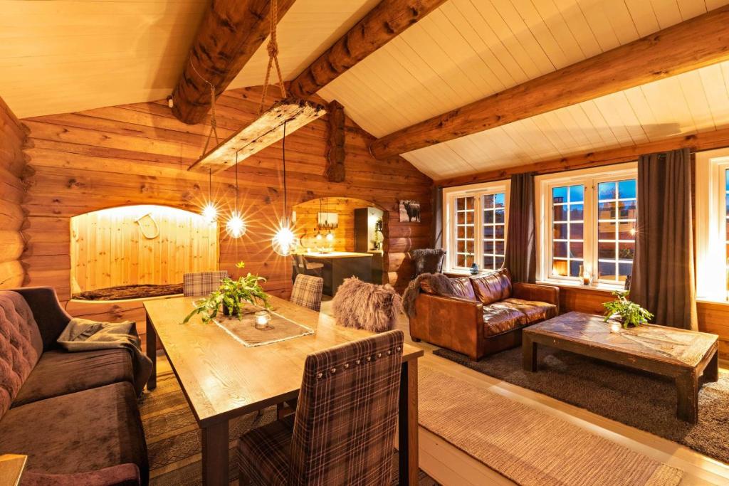 a living room with a couch and a table at Luxurious and modern log cabin close to nature in Lislevatn