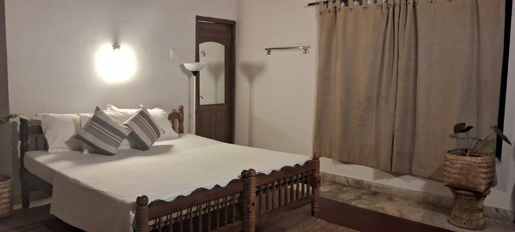 a bedroom with a bed with white sheets and pillows at The Clift in Varkala