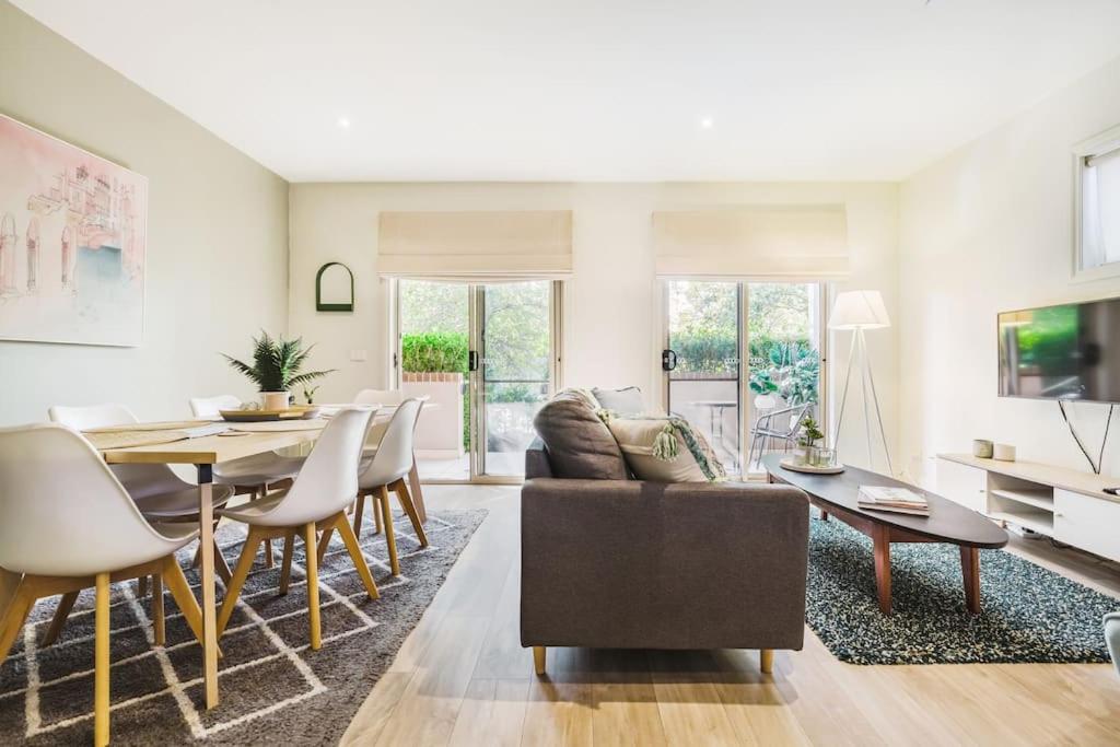 a living room with a couch and a table at Harp Haven - Contemporary in Suburban Tree lined Kew in Melbourne