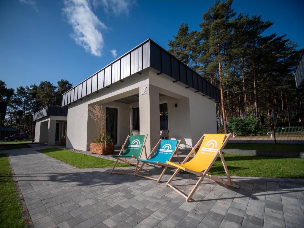 four lawn chairs sitting in front of a house at LABA Wieleń in Wielen Zaobrzanski