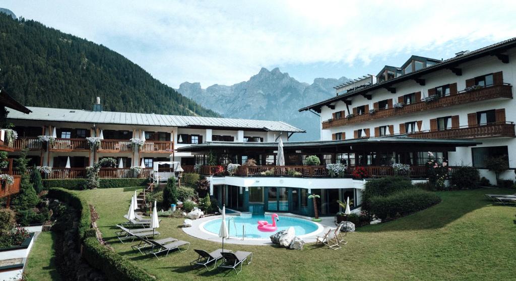 a hotel with a swimming pool in front of a building at Gut Wenghof - Family Resort Werfenweng in Werfenweng