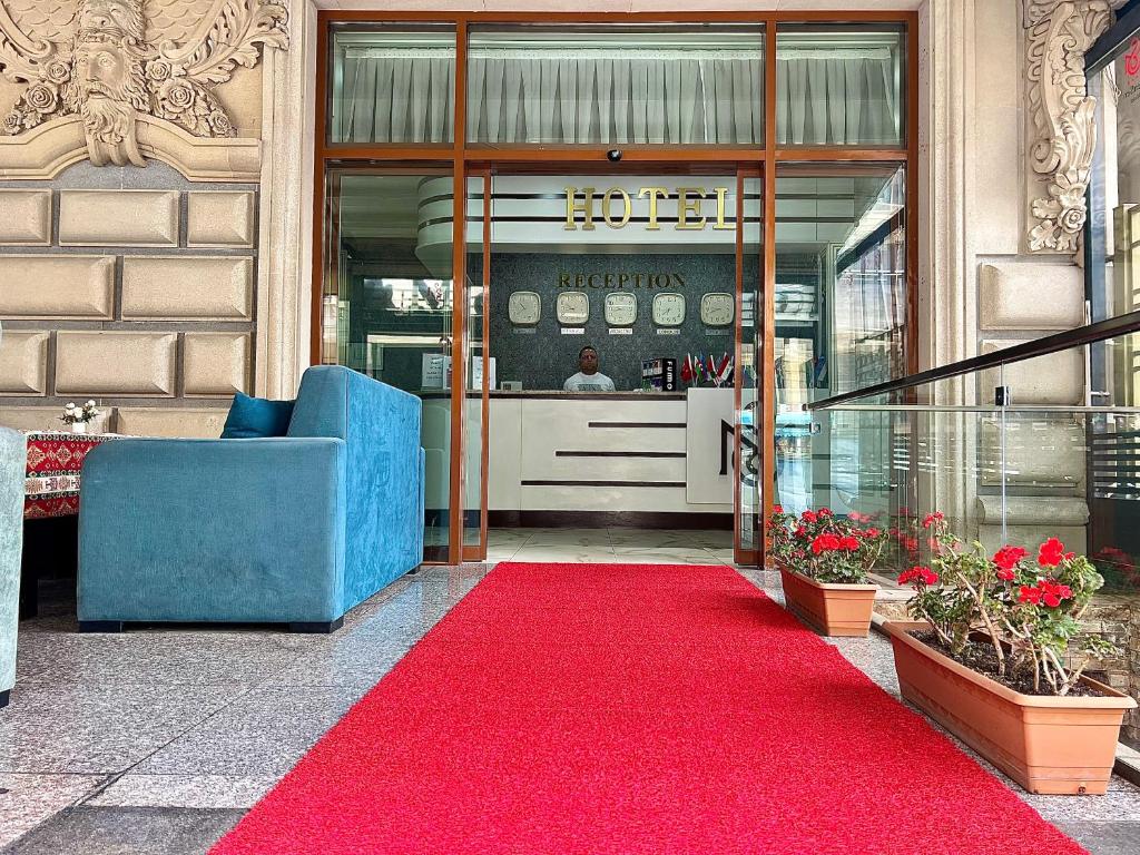 a red carpet in front of a store with a red rug at Mensen Hotel Baku in Baku