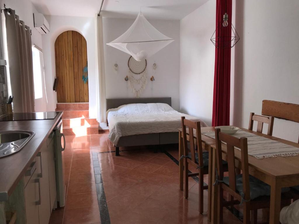 a kitchen with a table and a bed in a room at Casa o Futuro in Alcobaça