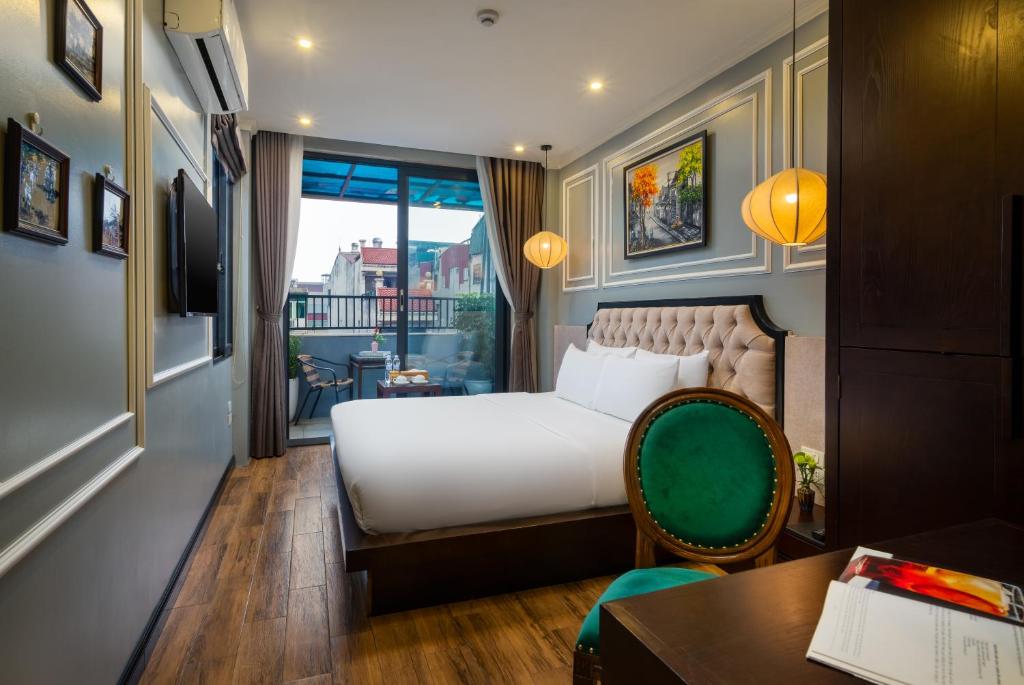 a hotel room with a bed and a desk and a window at Bella Rosa Hotel & Travel in Hanoi
