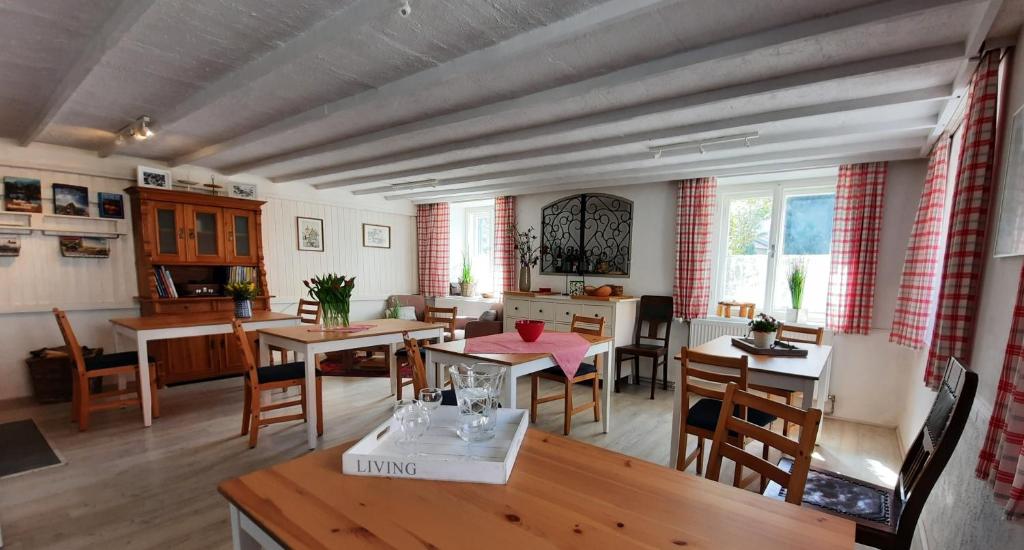 ein Wohnzimmer mit Tischen und Stühlen sowie ein Esszimmer in der Unterkunft B&B Leonhard 7 in Arnoldstein