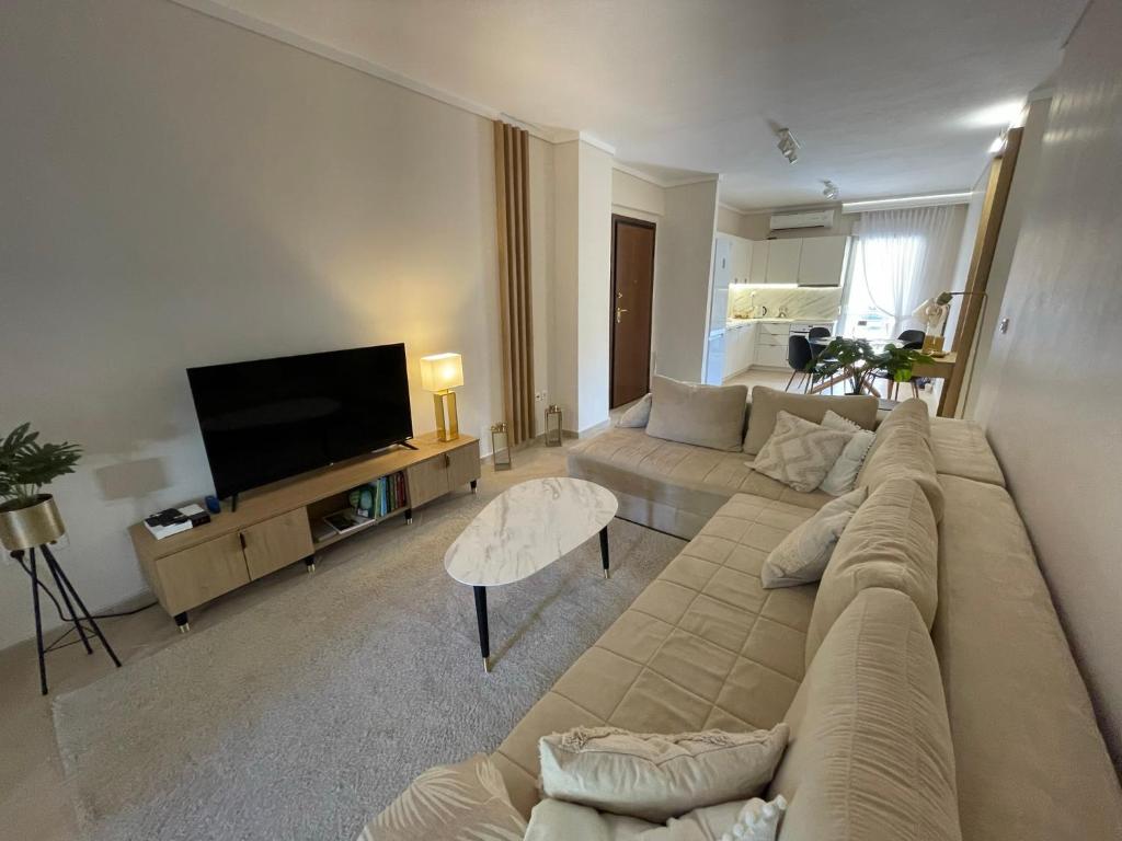 a living room with a large couch and a flat screen tv at Fterna Family Apartment Perea - 2 Bedrooms, Balcony, Near Beach & Airport in Perea
