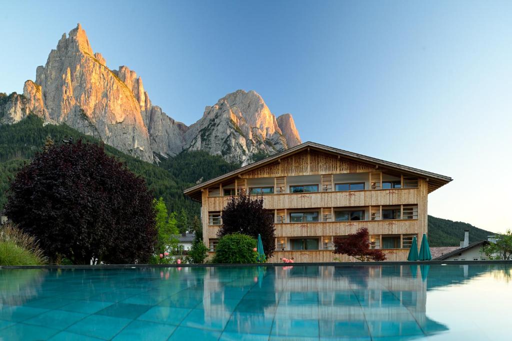 um hotel com uma montanha ao fundo em Artnatur Dolomites Hotel & Spa em Siusi