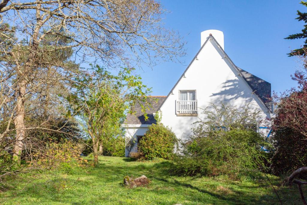 a white house with a window and trees at Grande maison familiale in Douarnenez