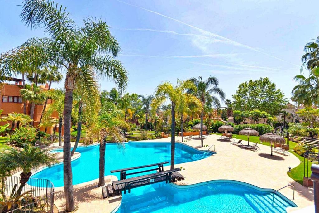 - une piscine bordée de palmiers et un complexe dans l'établissement Luxury 4 BD Penthouse with Private Pool by Hostlovers, à Marbella