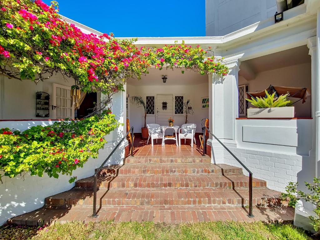 un patio con flores en las escaleras de una casa en Charming Family Home, en Ciudad del Cabo