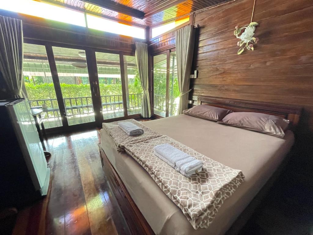 a bedroom with a bed in a room with windows at Ruen Orathai Resort in Prachuap Khiri Khan