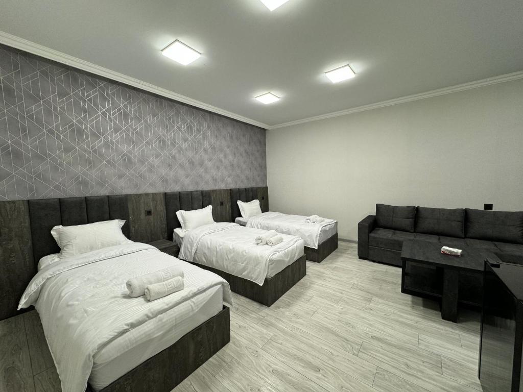 MeghriにあるVARDANANTS HOTEL Meghriのベッド2台とソファが備わるホテルルームです。