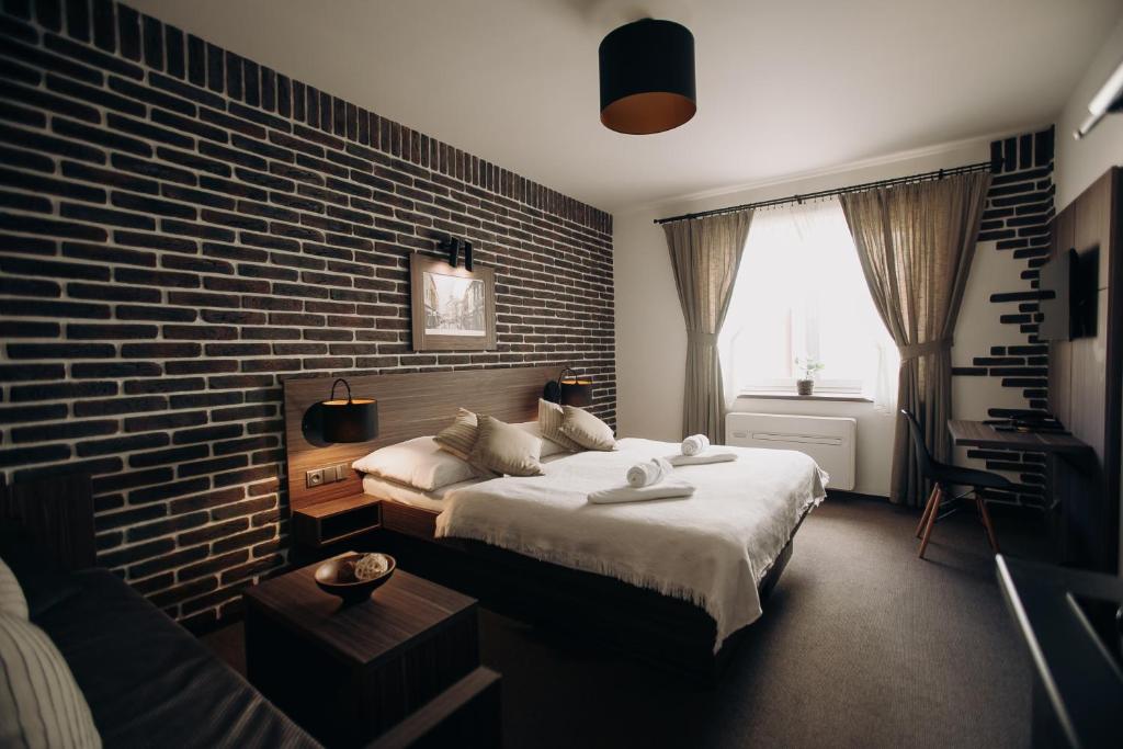 a bedroom with two beds and a brick wall at Penzion U Kubesa - Adults only in Kroměříž