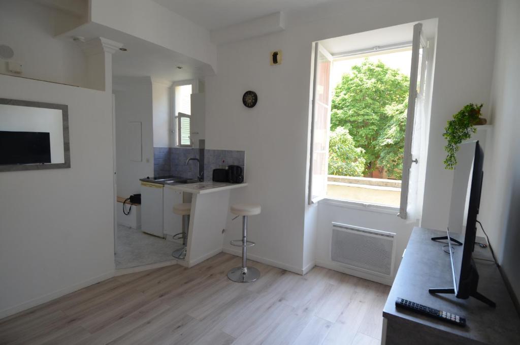 um quarto branco com uma secretária e uma janela em Superbe studio dans le quartier du port a 5min des lignes de tramway em Nice