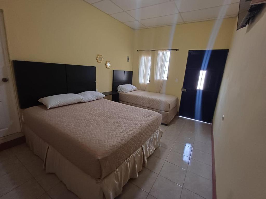 een hotelkamer met 2 bedden en een bank bij Hotel Villa Samperio in Poptún