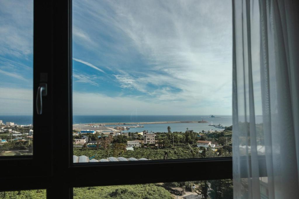 a view of the ocean from a window at Lemain Hotel Seogwipo in Seogwipo