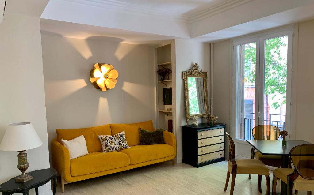 sala de estar con sofá amarillo y mesa en Hotel Bonaparte, en Bastia