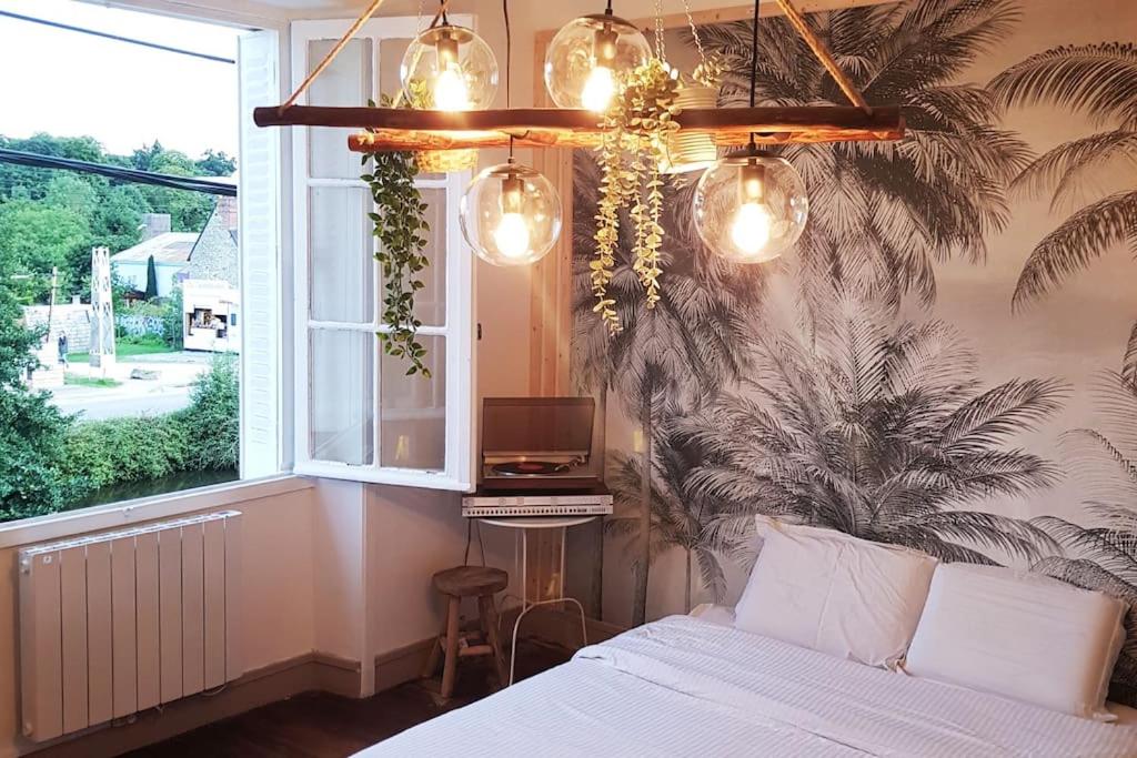 a bedroom with a bed and a window at Jungle Chic au bord du Canal Saint-Martin in Rennes