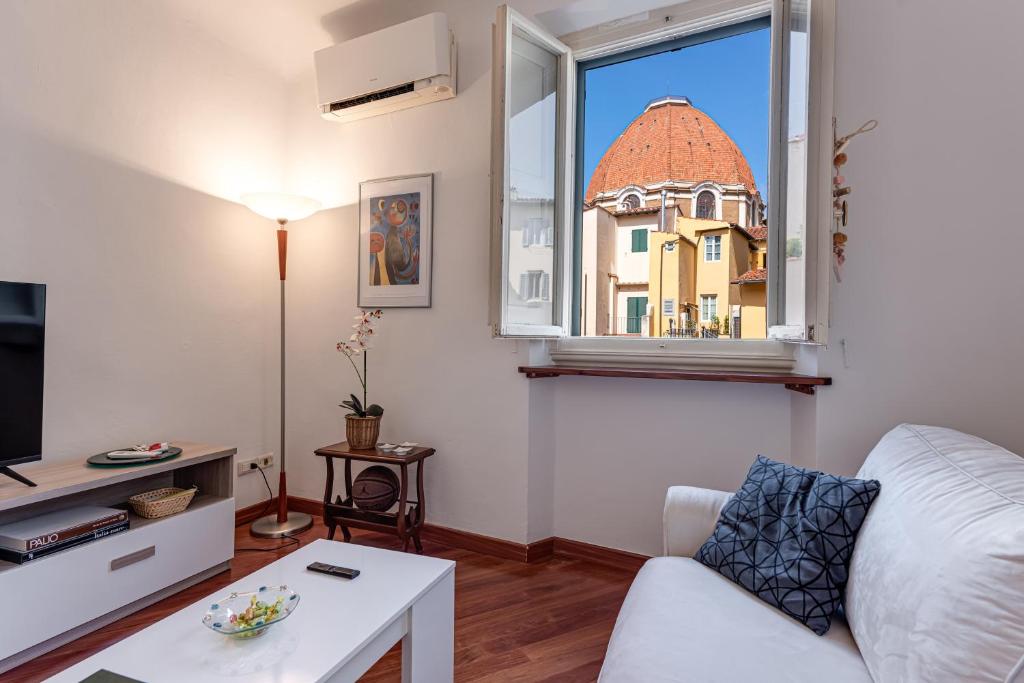 salon z białą kanapą i oknem w obiekcie Medici Chapels Apartment we Florencji