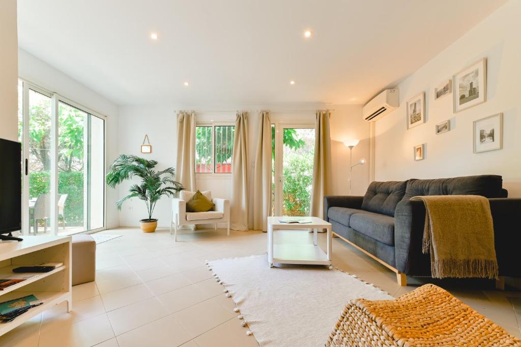 un salon avec un canapé et une table dans l'établissement Charmant Appartement - Jardinet Privé - 5 minutes des plages Sanguinaires - Ajaccio, à Ajaccio