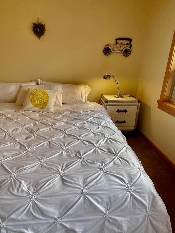 Un dormitorio con una cama blanca con una lámpara. en Fantastic views en Canmore