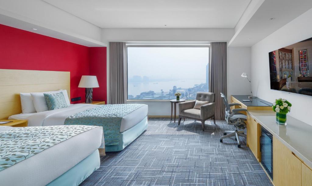 Habitación de hotel con 2 camas y escritorio en Marco Polo Wuhan en Wuhan