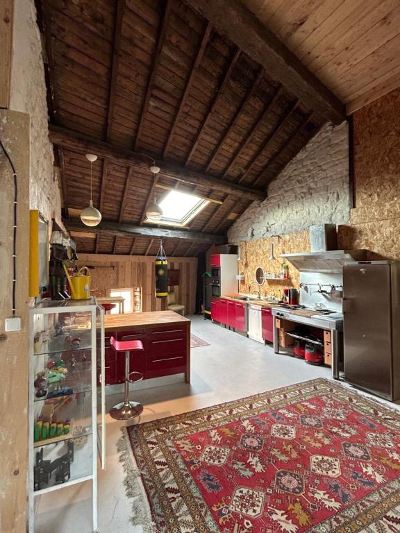 - une grande cuisine avec un tapis au sol dans l'établissement Le grenier de la place d'Isly, à Verdun-sur-Meuse