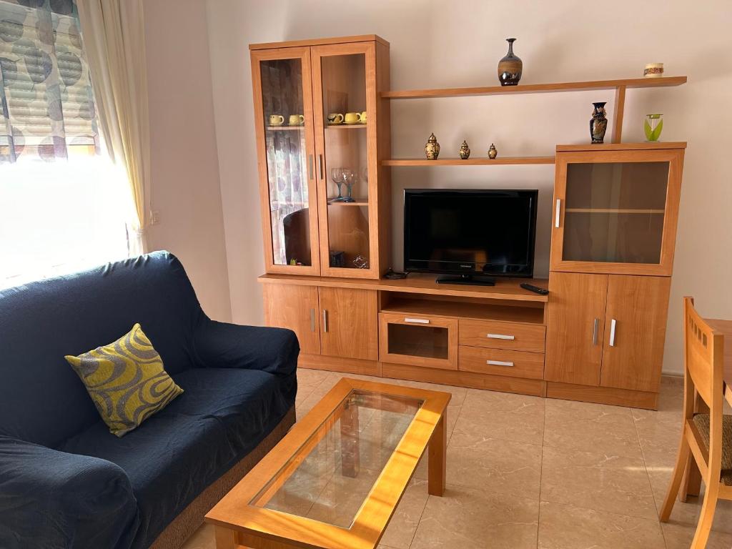a living room with a blue couch and a tv at Carolina apartamento de Luxe in Mazarrón