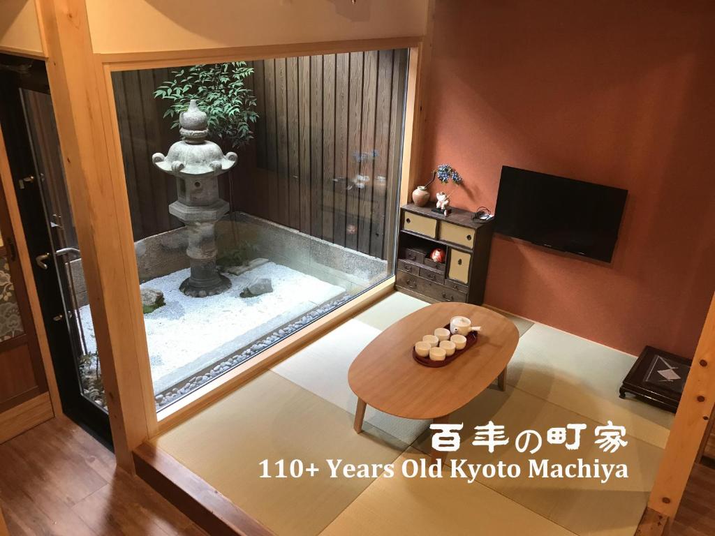 a living room with a view of a japanese fountain at Nishodo Machiya HIKARU OIKE in Kyoto