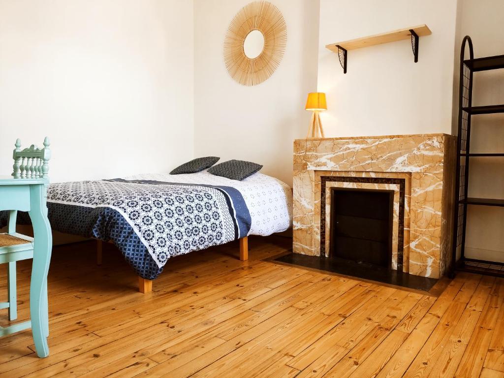- une chambre avec un lit et une cheminée dans l'établissement Le Cocon Stéphanois, à Saint-Étienne