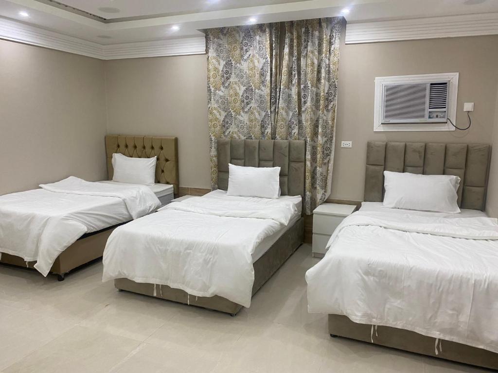 1 dormitorio con 2 camas y ventana en شقق مساكن الاميره en Yanbu