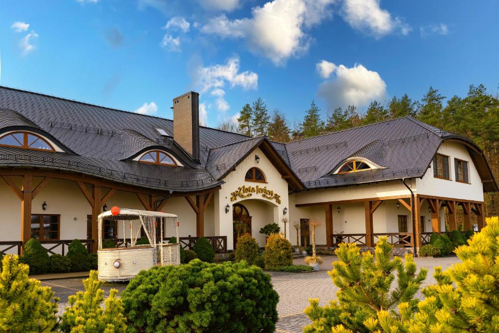 a large white house with a black roof at Złota Jesień Restauracja i Noclegi nad jeziorem in Kartuzy