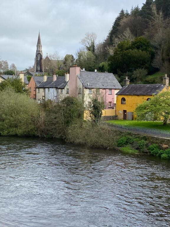 una pequeña ciudad con un río y una iglesia en Knockview, en Aughrim