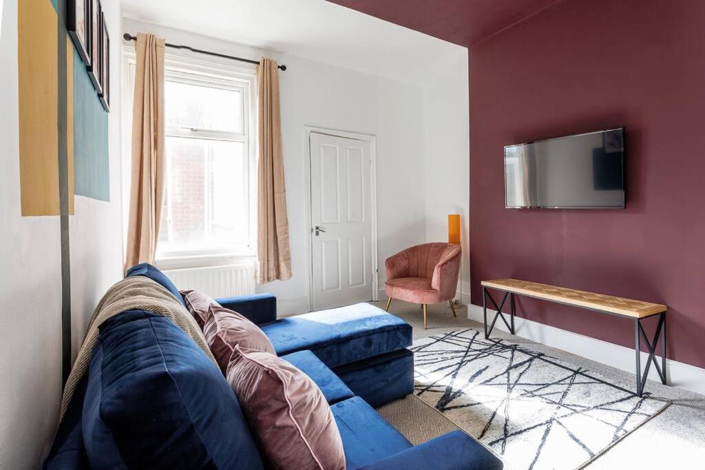 Comfortable stay at 2 BR house في جنوب شيلْدْز: غرفة معيشة مع أريكة زرقاء ونافذة
