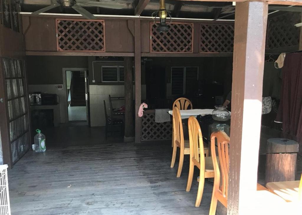 a dining room with a table and chairs in a house at Kampung In The City in Seri Kembangan